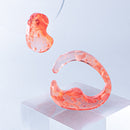 使用限界を超え廃棄されるカプセルトイのカプセルから生まれたオリジナルのアクセサリー「mom(マム)」です。 有限会社三幸の装飾アクリル板製造技術によって作られた、浮遊感のある水中のような表情が美しいアクリル素材を使用。 ミニチュアが入っていたカプセルからインスピレーションを受け、豆型のピースが包み込まれるようにデザインされたイヤーアクセサリーです。 イアーカフとピアス(イアリング)をセパレートで使用できます。KiNaKoとのコラボレーションによって生まれました。 デザイン/KiNaKo