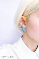 使用限界を超え廃棄されるカプセルトイのカプセルから生まれたオリジナルのアクセサリー「mom（マム）」です。 有限会社三幸の装飾アクリル板製造技術によって作られた、浮遊感のある水中のような表情が美しいアクリル素材を使用。 ミニチュアが入っていたカプセルからインスピレーションを受け、豆型のピースが包み込まれるようにデザインされたイヤーアクセサリーです。 イアーカフとピアス（イアリング）をセパレートで使用できます。KiNaKoとのコラボレーションによって生まれました。 デザイン/KiNaKo