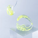 使用限界を超え廃棄されるカプセルトイのカプセルから生まれたオリジナルのアクセサリー「mom（マム）」です。 有限会社三幸の装飾アクリル板製造技術によって作られた、浮遊感のある水中のような表情が美しいアクリル素材を使用。 ミニチュアが入っていたカプセルからインスピレーションを受け、豆型のピースが包み込まれるようにデザインされたイヤーアクセサリーです。 イアーカフとピアス（イアリング）をセパレートで使用できます。KiNaKoとのコラボレーションによって生まれました。 デザイン/KiNaKo 