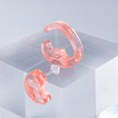 使用限界を超え廃棄されるカプセルトイのカプセルから生まれたオリジナルのアクセサリー「mom（マム）」です。 有限会社三幸の装飾アクリル板製造技術によって作られた、浮遊感のある水中のような表情が美しいアクリル素材を使用。 ミニチュアが入っていたカプセルからインスピレーションを受け、豆型のピースが包み込まれるようにデザインされたイヤーアクセサリーです。 イアーカフとピアス（イアリング）をセパレートで使用できます。KiNaKoとのコラボレーションによって生まれました。 デザイン/KiNaKo 